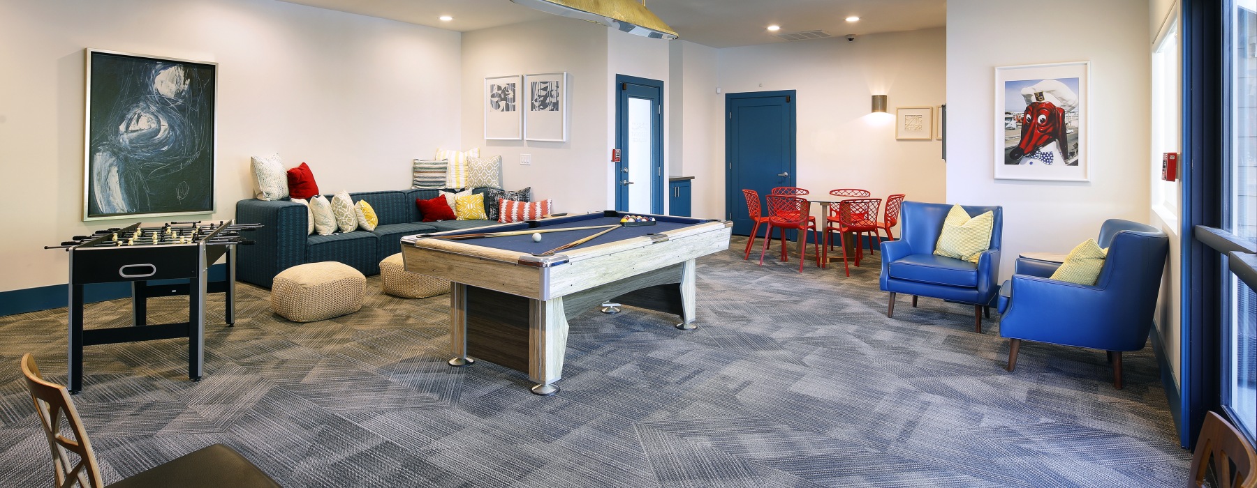 a lounge with couches, a pool table, and other games