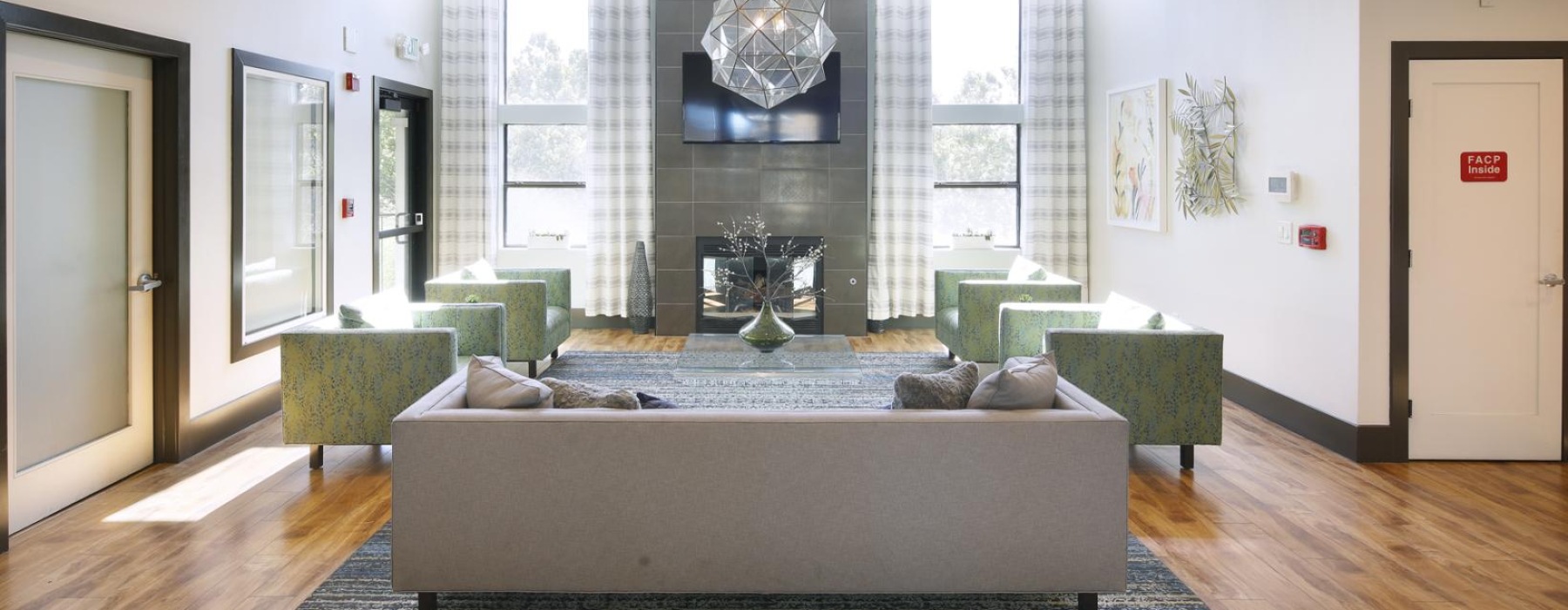 a lounge room with a fireplace and wood floors